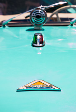 The emblem on the hood of a blue Amphicar, an amphibious automobile. 
