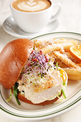 Grilled chicken breast burger with french fries on white plate  