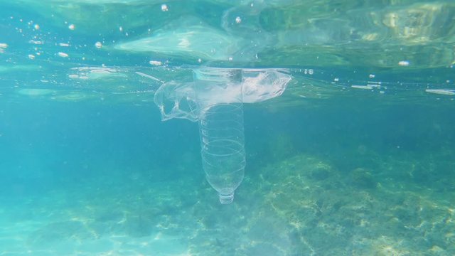 Plastic pollution in sea ocean - big environmental problem. Plastic bag and bottle flowting in sea. 