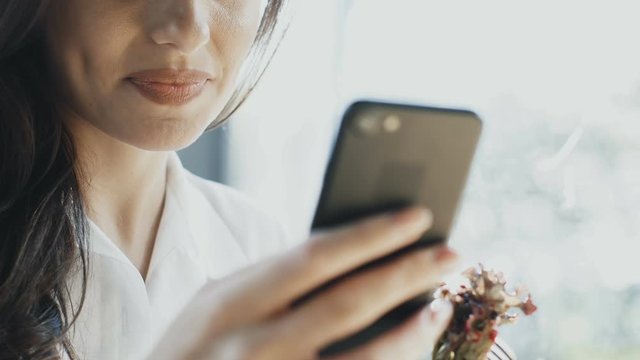 close-up of woman smile with arm holding phone and arm holding fok with salad