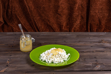 Tender low-fat cottage cheese with honey on a plate