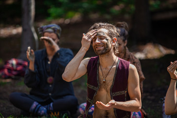 Diverse people enjoy spiritual gathering A mystical and enlightened man is viewed from the front,...