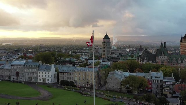 Aerial view of Canadian flag in front of Old Quebec City including Chateau Frontenac, Dufferin Terrace and Saint Lawrence River. Drone shot 4k with parallax