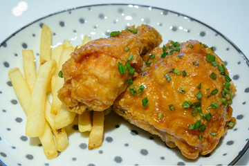 Spicy fried chicken and chips on a white polka dot dish.