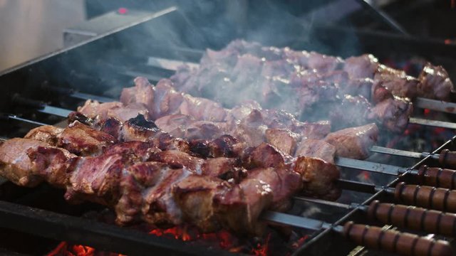 Closeup pork kebabs barbecuing at brazier outdoor.
