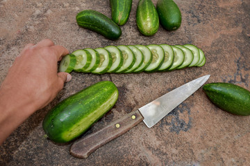 hand grabbing a cucumber