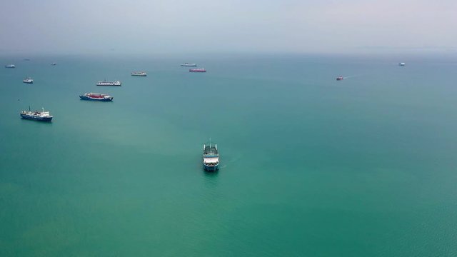 various ships anchored in the middle of the sea waiting their turn to dock at the port of Merak in Sunda Strait, Indonesia