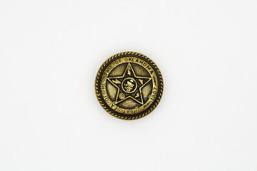 Old gilded iron button from an autumn military style coat, a metal button, a worn and rusted brass...