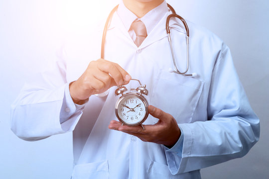 Doctor holding a clock,  Concept for timing, medical and healthcare