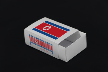 North Korea flag on white box with barcode and the color of nation flag on black background, paper packaging for put match or products.