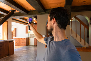 Indoor damp & air quality (IAQ) testing. A closeup view of a caucasian man using a hand held...