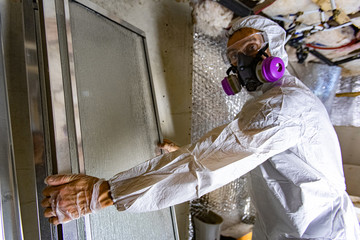 Indoor damp & air quality (IAQ) testing. A building inspector is seen at work inside a condemned...