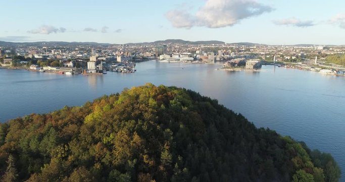 Cinema 4K drone shot with forward tilt reveal motion of Hoved&oslash;ya island, the Oslofjord and the Bj&oslash;rvika project, with the Lambda Munch Museum and Opera House in autumn fall, in Oslo Norway.