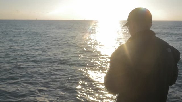fisherman shakes the rod in the sun