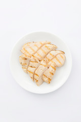close up of grilled chicken breasts on plate on white background.