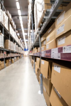 blurred brown goods boxes on full shelves in warehouse storage factory . perspective background with space for business about logistics shipping and wholesale concept . vertical picture .