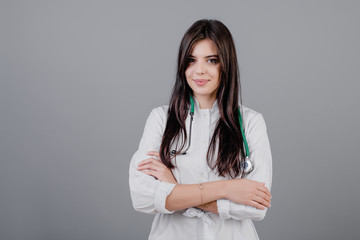 beautiful young smiling doctor in medical robe isolated over grey