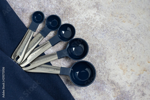 Metal Measuring Spoons With Dark Blue Bowl And Dark Blue Napkin On