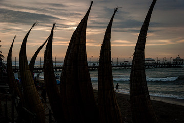 Caballitos de totora are artisanal boats builts with totora at Huanchaco beach at sunset hour in Trujillo, Perú.
