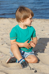 Baby boy on summer beach. Vacation time and child development concept