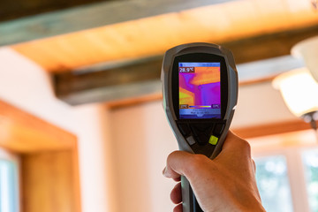 Indoor damp & air quality (IAQ) testing. An infrared thermal imaging device is seen in use, close...
