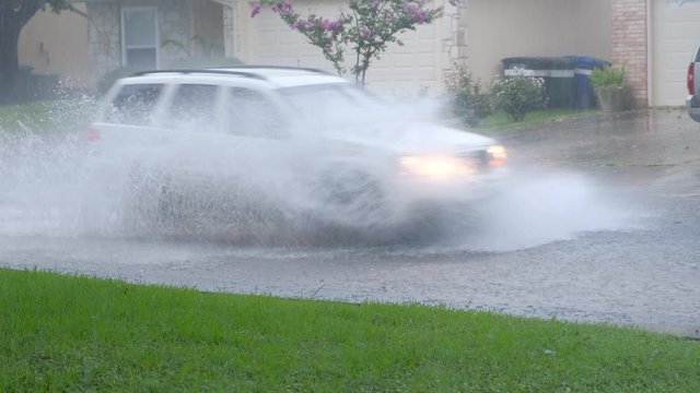	Car drives thru flood street in neighborhood after heavy rainfall
