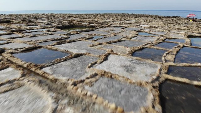An aerial low-altitude drone fly over of the Salt Pans on the Island of Gozo in Malta.