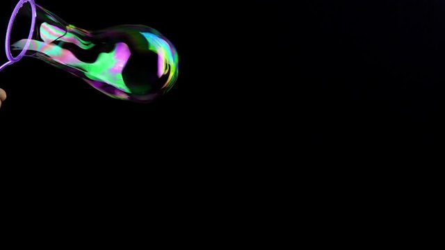 Hand making colorful soap bubbles background. Slow motion.