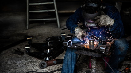 professional welder man working in protect uniform and helmet in industrial factory ,  manufacture linking and repair concept cover background .