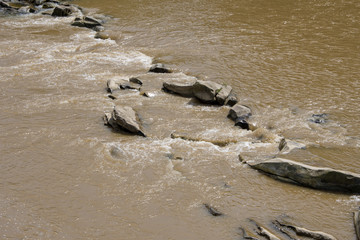 The descent of water from the mountains after the rain, the yellow river flows through the stones,