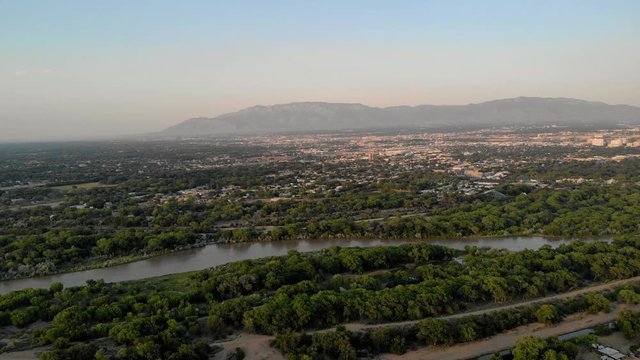 Drone flying over the Rio Grande River toward the city of Albuquerque, New Mexico. Viewing the Sandia Mountains in the background.