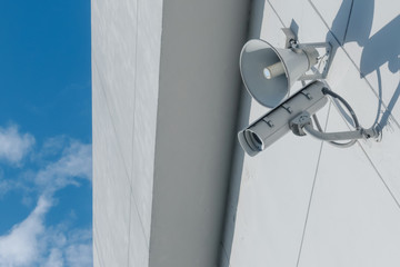 Loudspeakers and CCTV security cameras observation on a wall of a building