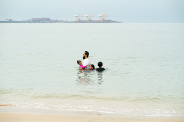 Happy Asian Family with Little Kid Having Fun at the Beach. Joyful Family. Travel and Vacation