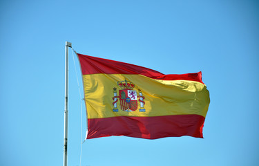 Spain flag waving over the blue sky