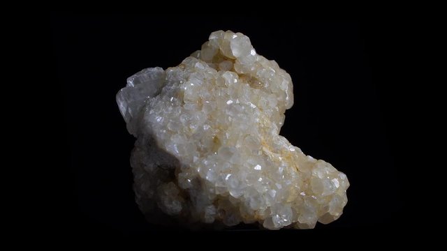 Macro shot of white crystal mineral, close-up footage with rotation. Isolated on black backround.