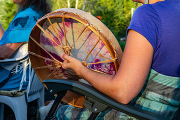 Sacred drums during spiritual singing. A close up and side view on the arm and hand of a young...