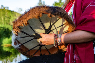 Sacred drums during spiritual singing. A spiritual music player is seen close up, wearing...