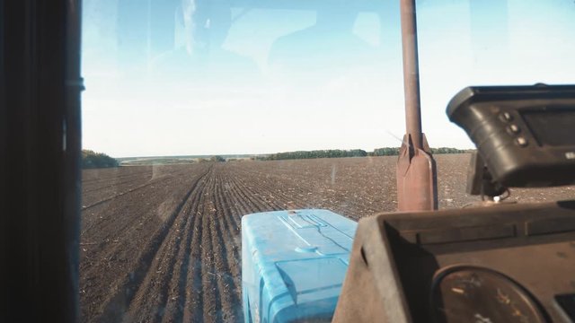 Farmer driving tractor in cultivating field. Agricultural works at tractor.