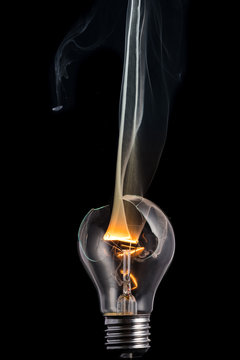 broken light bulb and smoke from a burning spiral on a black background