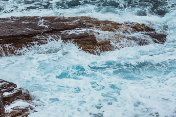 view of rocky sea beach in storm weather