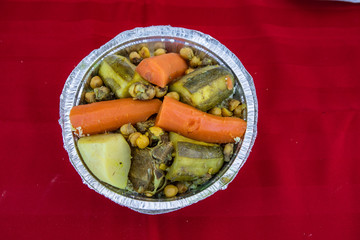 Fresh food at outdoor farmer's market. Vegetarian street food is seen close up and from above, served in a foil dish. Freshly prepared during a farming and agricultural fair.