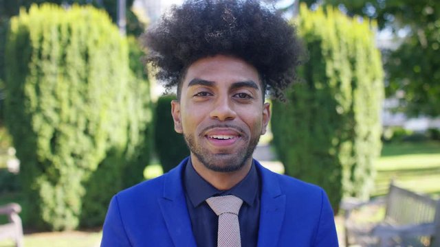 Attractive black male in a business suit talking to camera in a  vox pop interview style