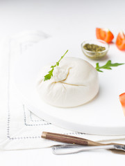 Burrata - Italian cheese, which is an excellent combination of mozzarella and cream on a white background
