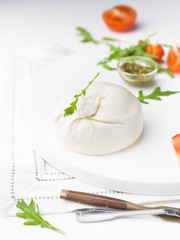 Burrata - Italian cheese, which is an excellent combination of mozzarella and cream on a white...