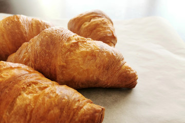 Croissants on a parchment paper. Copy space is on the right side. French pastry.