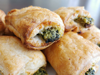Spinach puffs close up on a white plate.