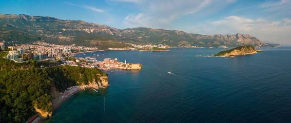 Obraz premium Aerial view of Mogren beach (two sandy beaches) and the old city (stari grad) of Budva, and Sveti Nikola island. Montenegro. Jagged coast on the Adriatic Sea