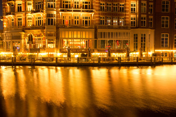 Fototapeta premium building architecture along canal against reflection of light night 