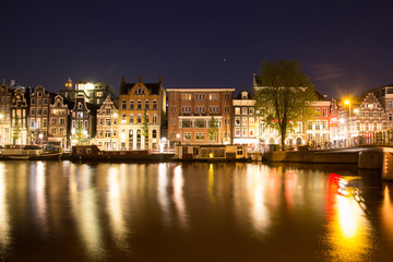 Fototapeta premium building architecture along canal against reflection of light night 