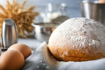 Fresh bread with raw eggs on table